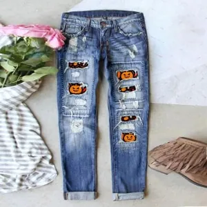 Detail of distressed blue jeans with Halloween pumpkin patches and washed denim texture