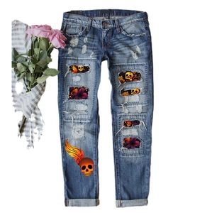 Jean bleu délavé avec écussons tête de mort et fleurs pour un look street unique