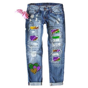 Women's ripped denim jeans with leopard print patches and colorful heart patterns