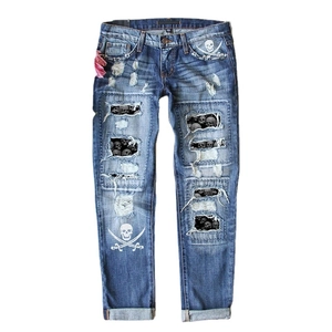 Distressed blue wash ripped jeans with skull prints and straight leg cut style