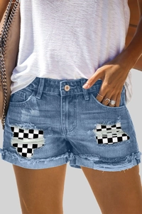 Dettaglio degli shorts in denim a vita alta con patchwork a scacchi trendy e orlo sfrangiato