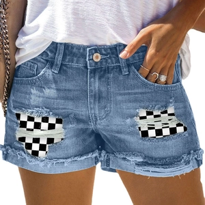 Pantaloncini in denim blu con strappi consumati e inserti patchwork a scacchi bianchi e neri
