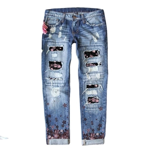 Jeans lavaggio blu con stampa fiori di ciliegio e toppe floreali per uno stile street