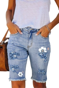 Women's light blue distressed denim bermuda shorts with leopard print patches and frayed hems