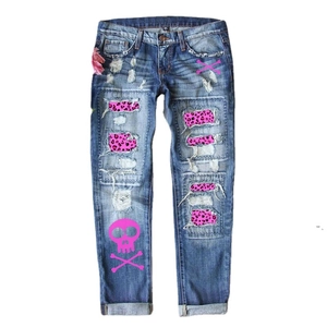 Jean ample bleu déchiré avec écusson léopard rose et motif tête de mort sur la jambe