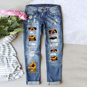 Detail of distressed jeans with Halloween witch patches and moon print on blue denim