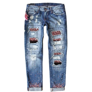 Distressed blue denim jeans with pink leopard print patches and rose gold sequins