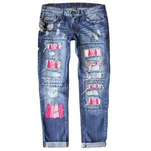 Jean bleu taille haute pour femme avec écussons graphiques et détails déchirés tendance
