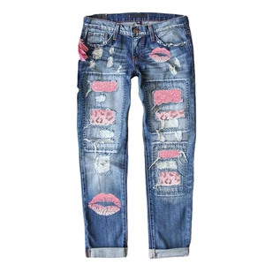 Jean slim bleu pour femme avec déchirures et écussons léopard roses et lèvres