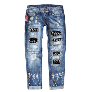 Women's blue distressed jeans featuring Halloween skull prints and ripped hole details