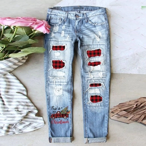 Light blue straight jeans with plaid patches and Christmas truck print in flat lay view