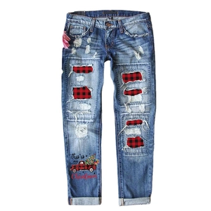 Women's light blue distressed jeans with Christmas truck print and red plaid patches