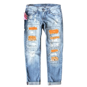 Jean bleu clair délavé avec patchs léopard et détails pailletés orange étincelants