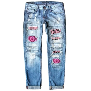 Women's light blue washed jeans with pink heart patches and ripped distressed denim details