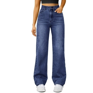 Detail of washed dark blue denim texture on loose straight wide leg jeans with cuffed hem
