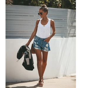 Short en jean bleu déchiré mode urbaine pour femmes avec débardeur blanc en extérieur