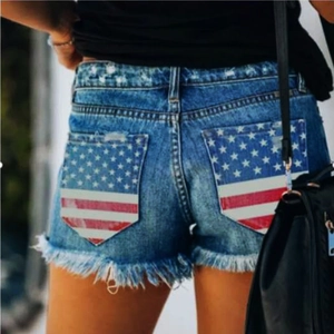Damen Denim-Shorts in Blau mit amerikanischem Flaggenprint auf den Taschen und Fransensaum