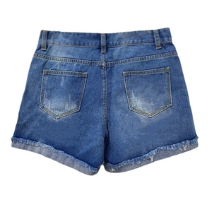 Détails de l'ourlet effiloché et délavage usé sur les poches arrière du short en jean