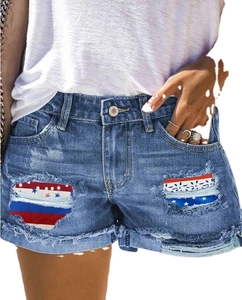 Women's blue distressed denim shorts with American flag patterned patches and cuffed hems