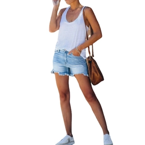 Women's summer outfit with white tank top and light blue frayed denim shorts
