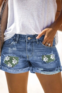 Mid-rise denim shorts with floral leopard print patches and frayed tassel hems