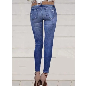 Jean skinny bleu pour femme avec taille mi-haute et détails usés sur les poches