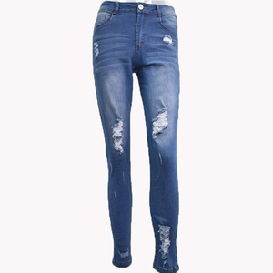 Gros plan d'un jean skinny bleu avec des genoux déchirés et des détails de délavage