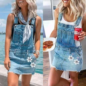 Detail von hellblauem Denim-Latzkleid mit Blumendruck und verstellbaren Metallschnallen