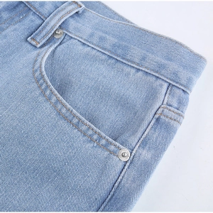 Detail view of light blue denim jeans showing waist, belt loops and metal rivet accents