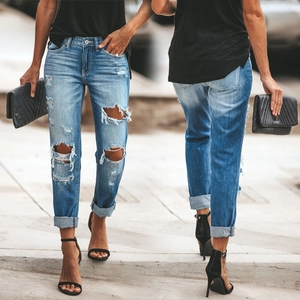 Détail de jean denim déchiré bleu clair avec genoux usés et ourlets repliés élégants