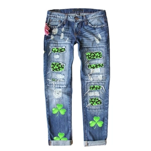 Jean droit bleu foncé avec patchs trèfles verts et détails usés de style vintage