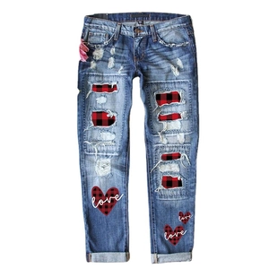 Distressed blue mid-waist jeans featuring love heart prints and red plaid patchwork