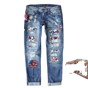 Distressed denim jeans with American flag sunflower patches and butterfly embroidery