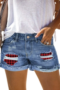 Women's mid-blue denim shorts with distressed ripped holes and red plaid fabric patches