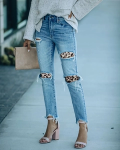 Dettaglio di jeans azzurri a vita alta con patchwork stampa leopardata sulle ginocchia