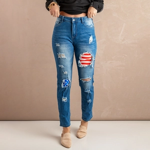 Detailed view of distressed denim jeans featuring USA flag patchwork inside rips