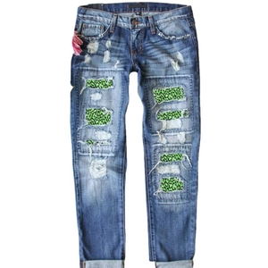 Distressed dark blue slim-fit jeans with neon green leopard print patches and rolled cuffs