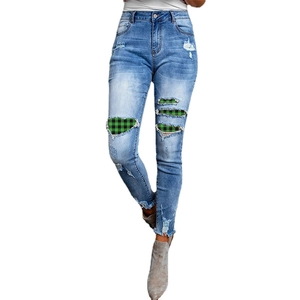 Women's high waist distressed blue jeans with green buffalo plaid patch detailing