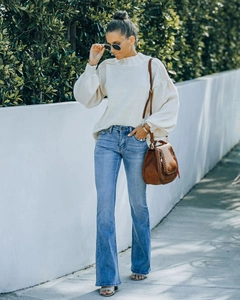 Outdoor street style featuring light blue high waist flare jeans and knit sweater