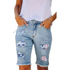 Distressed denim shorts with American flag patches and frayed hem for women