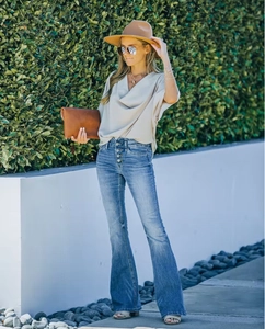 Full-body street style of flared light blue high-waist jeans with multiple buttons