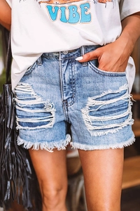 Détail d'un short en jean bleu clair avec des déchirures et un ourlet effiloché