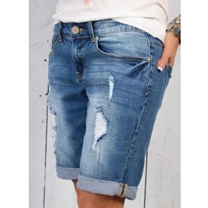 Détail d'un short en jean délavé avec déchirures et ourlets retroussés élégants