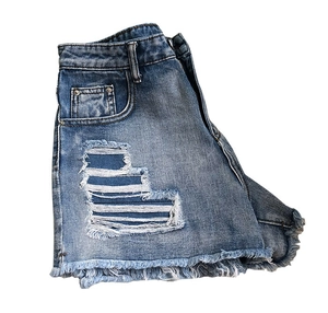 Détail d'un short en jean taille haute avec bords effilochés et texture de jean déchiré