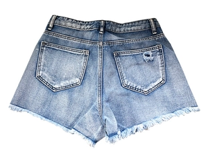 Détail des poches arrière du short en jean avec déchirures et bords effilochés à franges