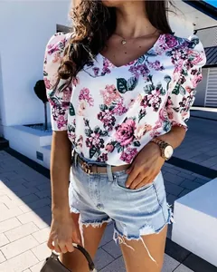 Détail des manches bouffantes sur une blouse à col en V avec motif fleuri violet