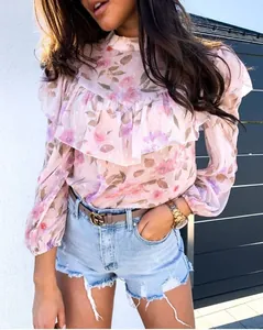 Détail de la blouse en mousseline fleurie rose avec décolleté à volants élégants