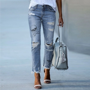 Women's distressed denim jeans with skull prints and raw frayed hem in a slim fit