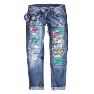 Women's ripped straight leg jeans with rainbow tie-dye patches and distressed blue finish