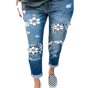 Women's ripped denim jeans with daisy and leopard print patches in slim fit style
